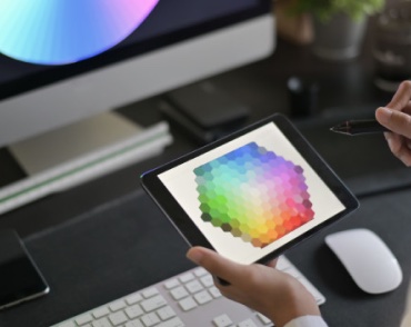 desk with hands holding tablet with color wheel displayed